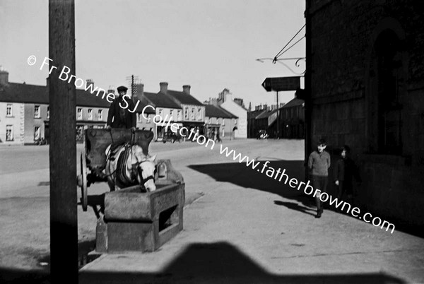 STREET WITH HORSE DRINKING FROM TROUGH